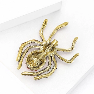 Golden vintage spider brooch with rhinestone accents shown from the back with pin clasp