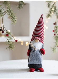 Détail d'un gnome de Noël nordique avec bonnet rayé et barbe blanche sur une table