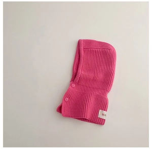 Detail of bright pink knitted balaclava for kids with button closure and logo label
