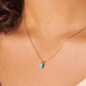 Detail of 18K gold-plated necklace with a rectangular sky blue zircon birthstone pendant