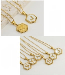 Macro detail of hexagonal 18K gold plated stainless steel necklaces with white shell inlay