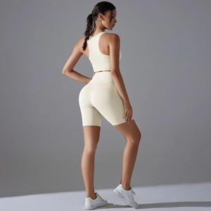 Dettaglio del retro di un set da yoga crema con reggiseno sportivo e pantaloncini a vita alta