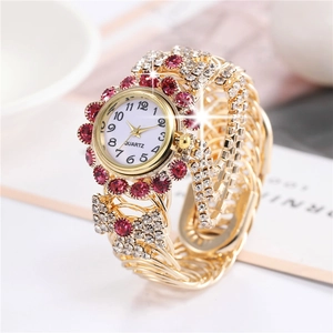 Close-up of gold quartz watch with red rhinestones and clear crystals on the wristband