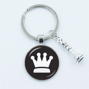 Silver chess king pendant keychain with crown motif on a black circular base