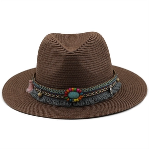 Close-up of bohemian embroidery and turquoise beads on a dark brown straw fedora hat