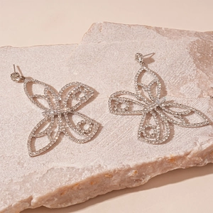 Detailed close-up of silver hollow butterfly earrings with sparkling cubic zirconia stones