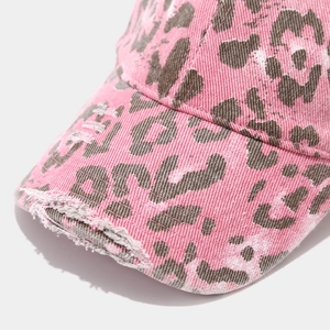 Macro detail of pink leopard print baseball cap featuring distressed brim and cotton texture