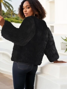 Back view of a stylish black faux fur jacket in an outdoor setting with a minimalist vibe