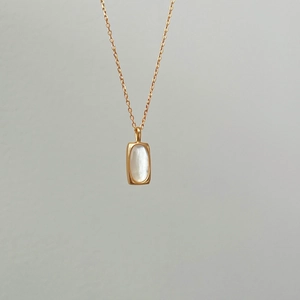 Detailed close-up of S925 silver necklace with golden chain and rectangle shell pendant