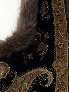 Detail of beaded embroidery and faux fur trim on black velvet vest for women