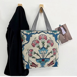 Detailed embroidery texture on ethnic canvas tote bag with floral patterns