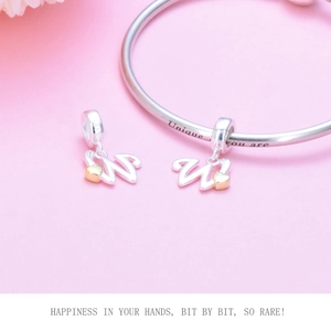 Macro detail of S925 silver heart charm with letter W on a signature snake chain bracelet