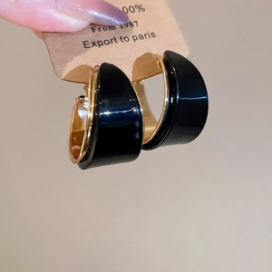 Vue détaillée des créoles en forme de C avec placage en or 18 carats et résine noire