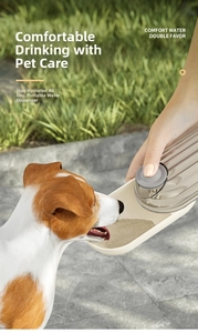 Close-up of a small dog drinking from a portable beige pet water bottle outdoors