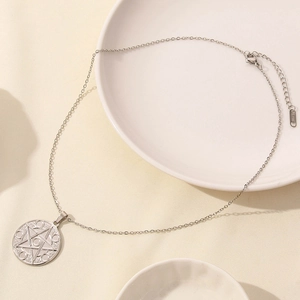 Dettaglio della collana con stella argento e timbro del materiale S.STEEL inciso