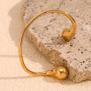 Detail of 18K gold-plated stainless steel teardrop bangle with sparkling pave zircon accents