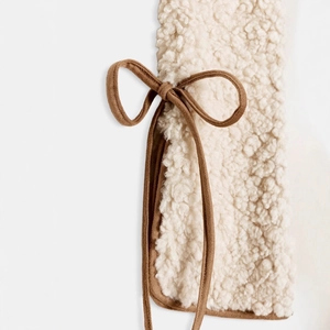 Elegant off-white faux fur vest with brown tie closure and soft plush texture finish