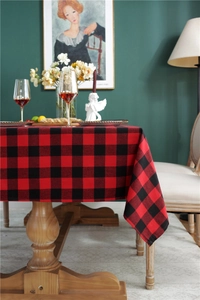Close-up of red and black buffalo plaid festive tablecloth on a rustic wooden table