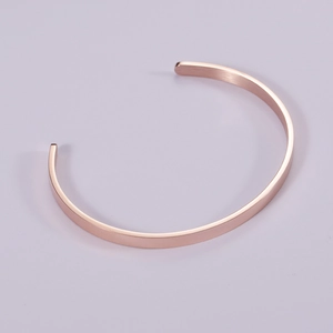 Detailed view of rose gold C-shaped open cuff bracelet with a brushed matte finish