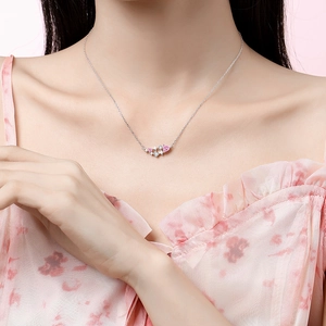 Pink heart and star planet pendant necklace on woman's collarbone with silver chain