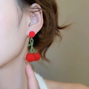 Handmade cherry drop earrings with red pom-pom studs and beaded fruit charms