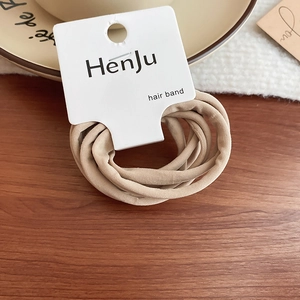 Close-up of flexible khaki elastic hair bands set on a natural wood surface background