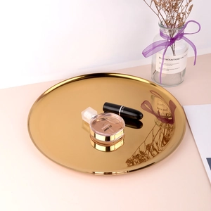 Close-up of golden stainless steel tray reflecting luxury perfume and lipstick items