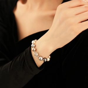 Detailed view of multicolor pearl necklace with diamond magnetic clasp on a female model