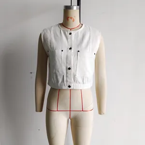 Detailed view of the white denim vest showing metal buttons and large utility pockets