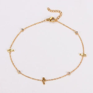 Detail of gold musical note anklet with treble clef pendant and sparkling rhinestone