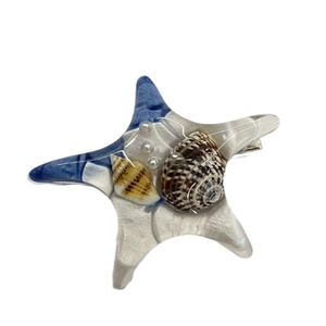 Barrette étoile de mer en résine bleue avec mini coquillages et perles sur fond blanc