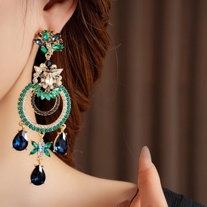 Détail de boucles d'oreilles vintage avec cristaux bleu et vert sur un mannequin