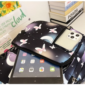 Detail of black butterfly and moon printed laptop sleeve showing internal storage pockets