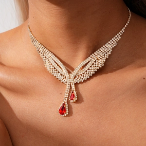 Macro view of silver fringe necklace featuring pear-shaped red gemstones and pavé zircons