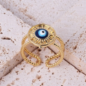 Detail of evil eye ring featuring gold twisted band and blue enamel inlay on stone base