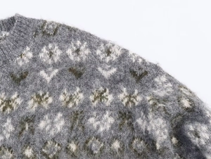 Detailed close-up of dark grey jacquard knit sweater with fuzzy mohair texture and floral pattern