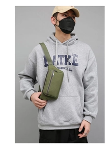 Army green nylon chest bag with multiple zipper pockets shown on a male model