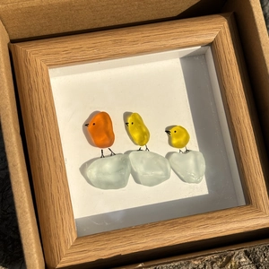 Détail de l'art en verre de mer oiseaux dans un cadre en bois avec pièces orange et jaunes