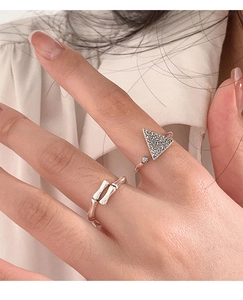 Primer plano de anillos de plata S925 con motivos de bambú y triángulos en el dedo