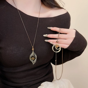 Detail of layered gold necklaces with tiger eye stone pendants on a black garment
