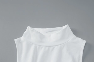 Close-up of high-neck sleeveless white dress showing neckline detail and fabric texture