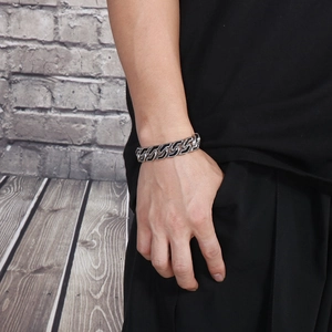 Men's punk style stainless steel chain bracelet with black striped inlay on a male wrist