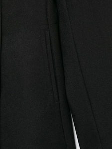 Detailed macro view of pocket craftsmanship on black wool blend twill coat fabric