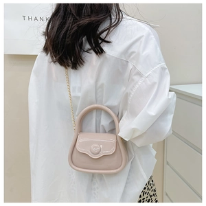 Close-up of mini jelly handbag in nude pink featuring gold chain and glossy texture