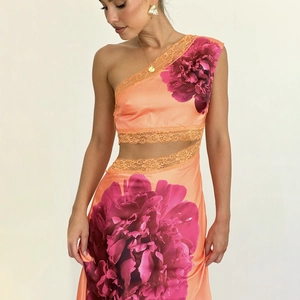 Détail de la robe en satin fleuri orange-rose avec dentelle et découpe à la taille