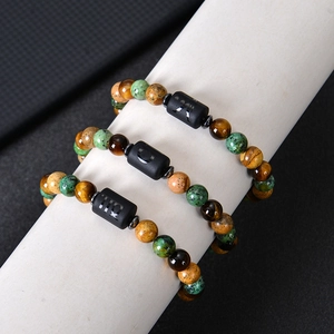 Macro shot of tiger eye beaded bracelets with Virgo Taurus and Capricorn zodiac charms
