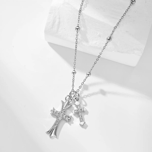 Detail of silver double cross pendant necklace with micro-pave zircons and beaded chain
