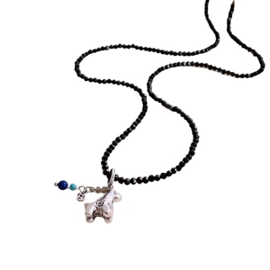 Minimalist black beaded necklace with a vintage silver pony pendant and coin motifs
