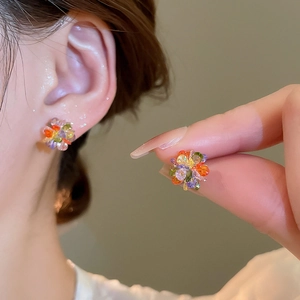 Detail of floral earrings made from colorful crystal beads worn on the earlobe