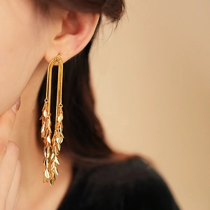 Close-up of elegant gold leaf tassel earrings with multi-layered metallic dangles